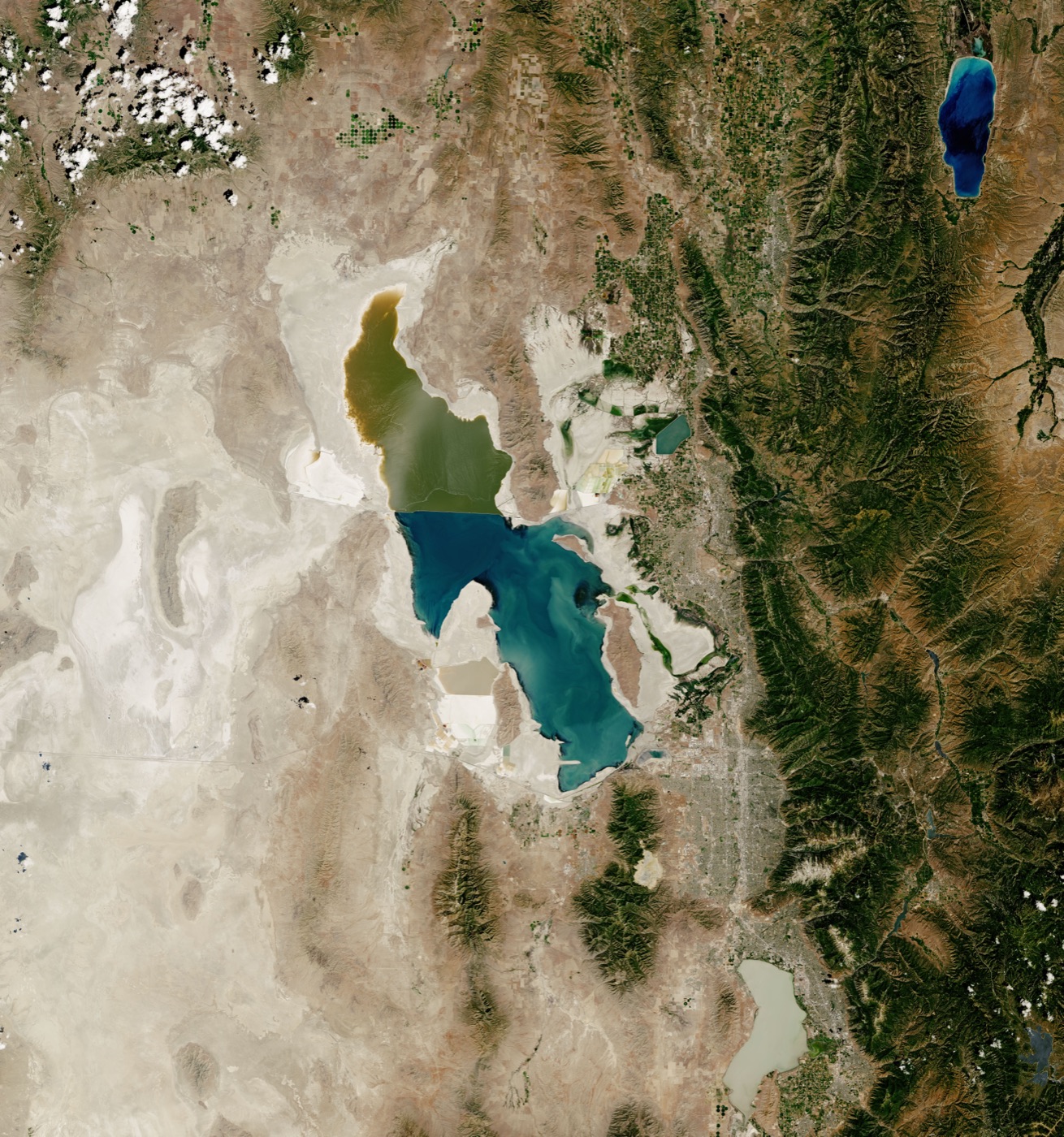 NASA Landsat satellite image of the Great Salt Lake in July 2022 at its record low, showing extensive exposed white lakebed, a fragmented southern arm, and a hyper-saline pink northern arm